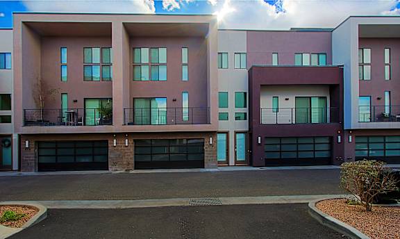 A modern building with a mix of pink and grey exterior.