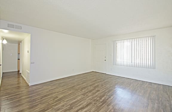 the spacious living room with wood flooring and a large window