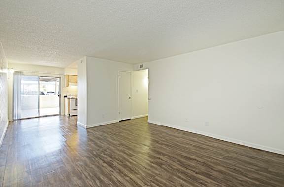 A room with wooden flooring and white walls.