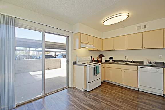 A kitchen with white appliances and wooden cabinets.