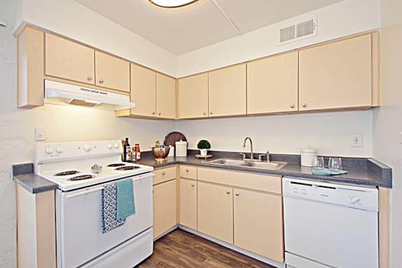 A kitchen with a white stove and white oven.