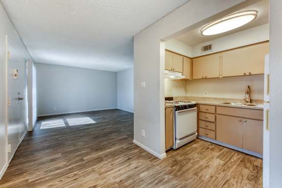 A kitchen with wooden floors and a refrigerator.