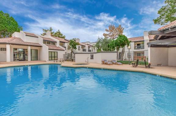 A large swimming pool in front of a row of houses.