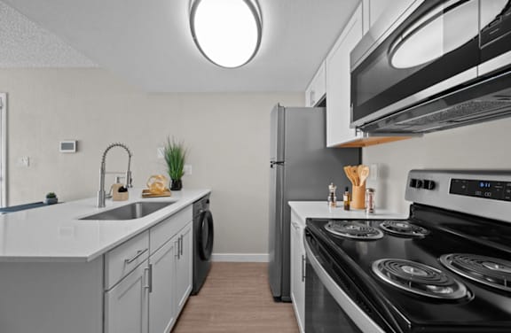 A modern kitchen with a black stove top oven and a white countertop.