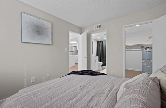 A bedroom with a large bed and a mirror on the wall.