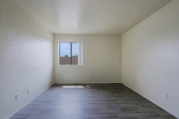 A room with a window and wooden flooring.