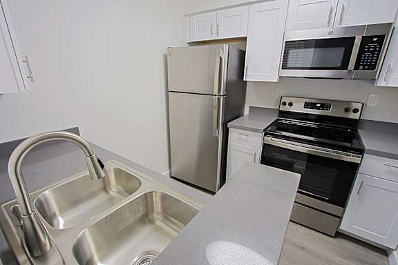 A kitchen with a stainless steel refrigerator, oven, and microwave.