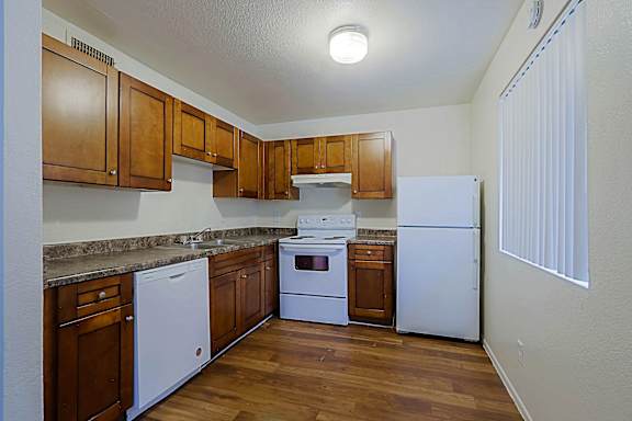 A kitchen with white appliances and wooden cabinets.