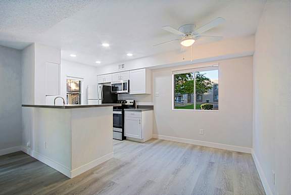 A kitchen with a white counter and a window.