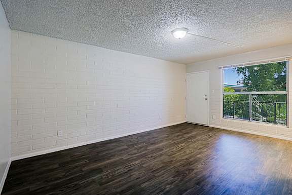 A room with white brick walls and wooden flooring.