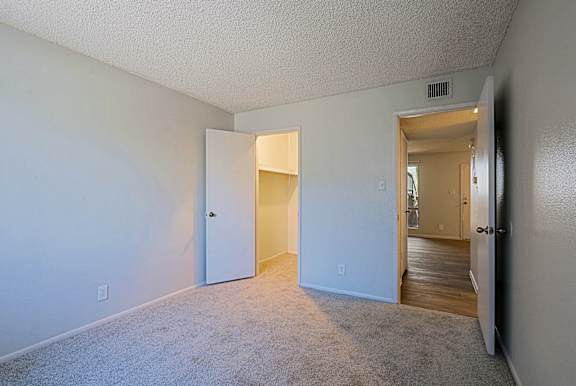 A room with a carpeted floor and two open doors.