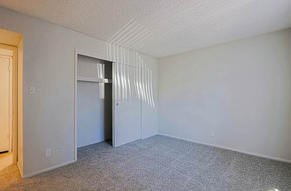 A room with a carpeted floor and a door.