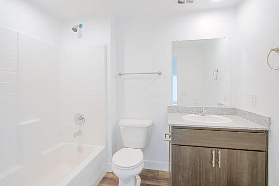 a bathroom with a toilet sink and tub and a mirror at 2051 Apartments, Prescott, Arizona