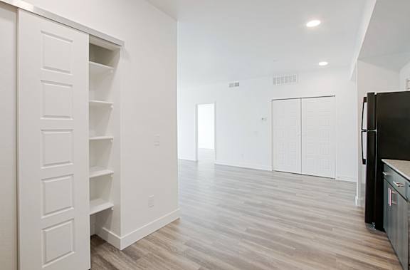 a kitchen and living room with white walls and a black refrigerator at 2051 Apartments, Arizona