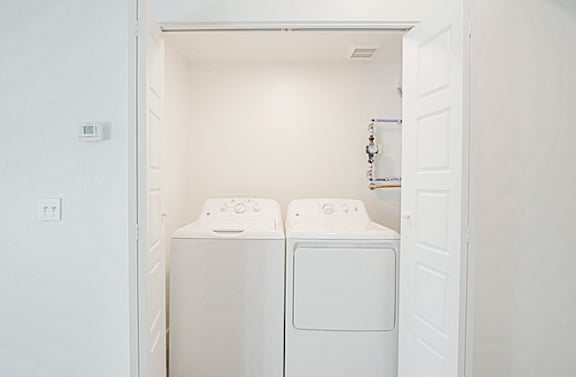 a white laundry room with two washes and a dryer at 2051 Apartments, Prescott, AZ, 86301