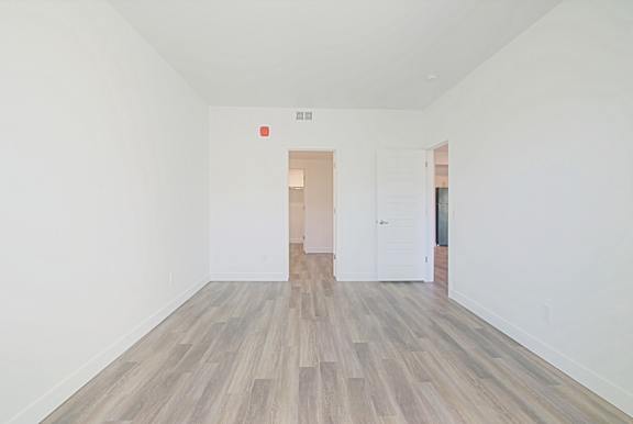 an empty room with white walls and wood floors at 2051 Apartments, Prescott, 86301