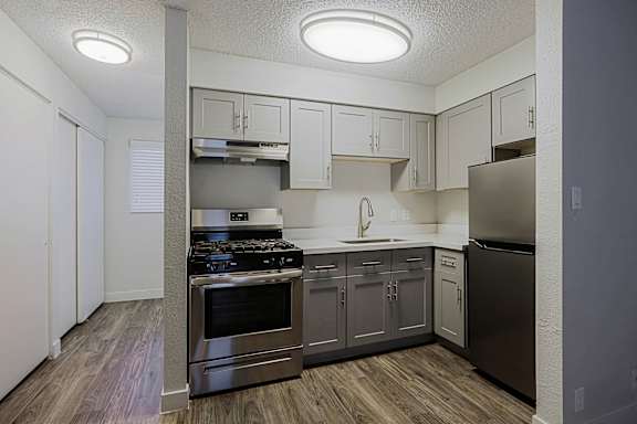 A kitchen with a stove top oven and a refrigerator.