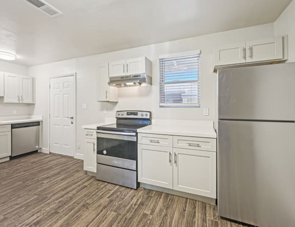 A kitchen with white cabinets and stainless steel appliances.