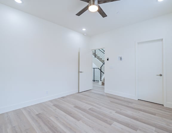 A room with a wooden floor and a ceiling fan.