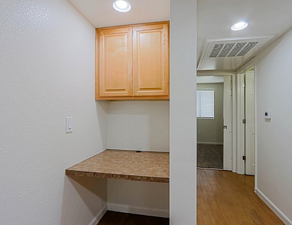 A kitchen area with wooden cabinets and a countertop.