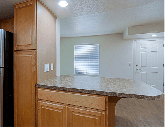 A kitchen with wooden cabinets and a granite countertop.
