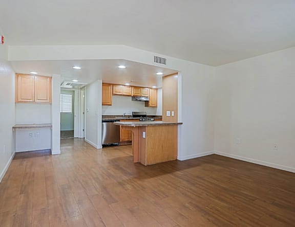 A kitchen with wooden floors and cabinets.