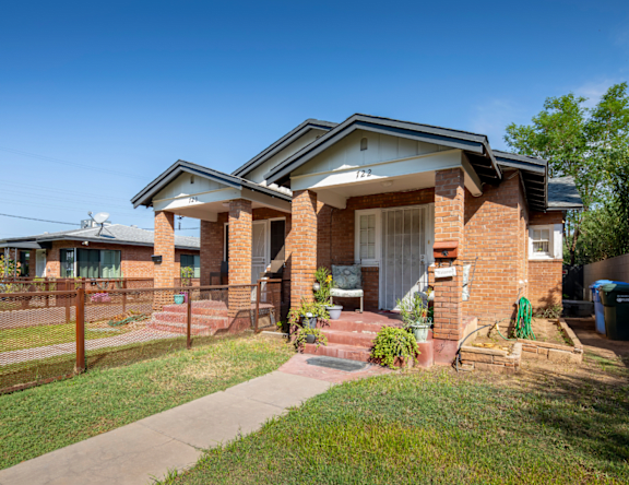 A house with a white door and a brick wall.