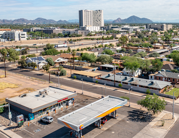 A gas station in the middle of a deserted parking lot.
