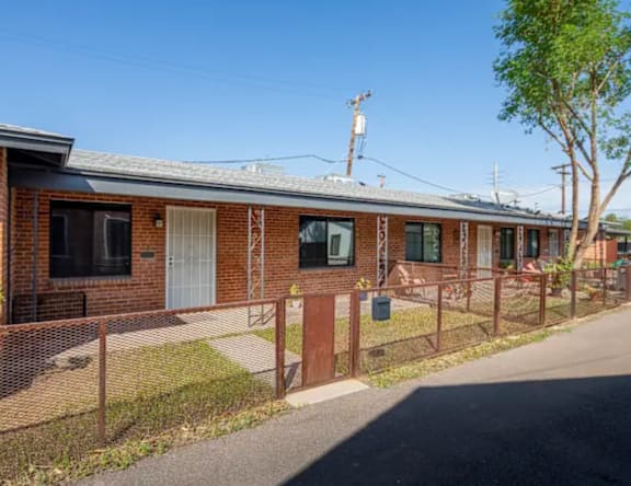 A row of houses with a fence in front.