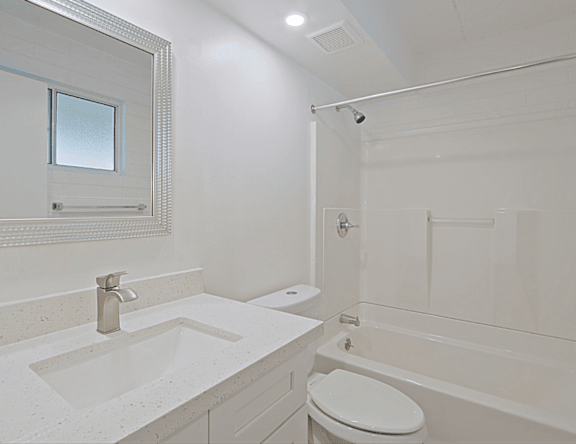 A white bathroom with a sink, toilet, and bathtub.