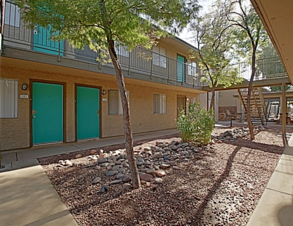 A building with green doors and a small garden in front.