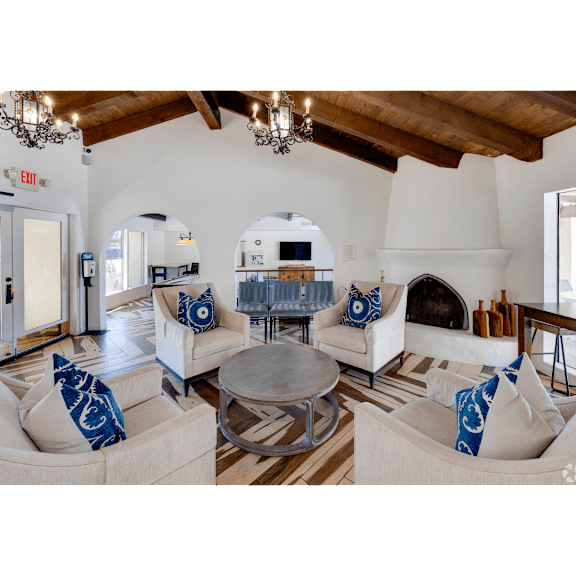 A living room with a fireplace and a couch with blue pillows.