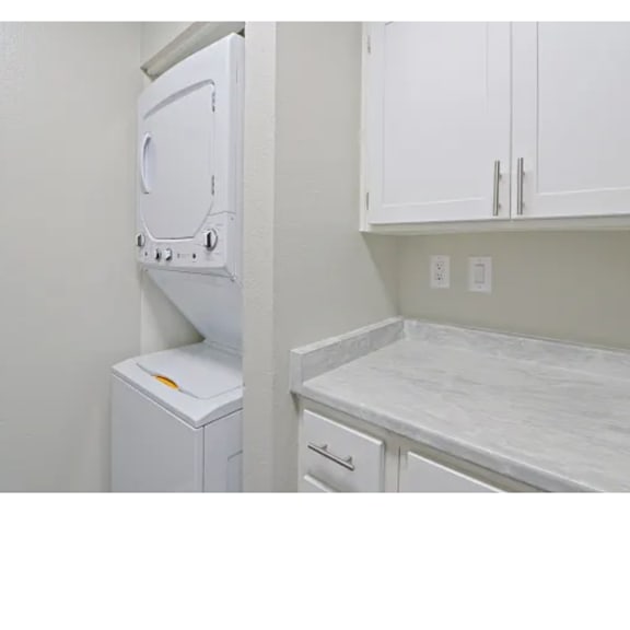 A white dishwasher is next to a white washing machine in a kitchen.