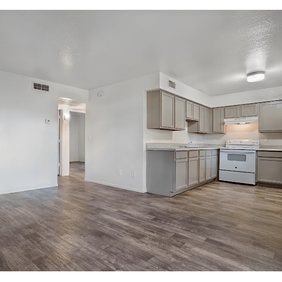 A kitchen with wooden floors and white walls.