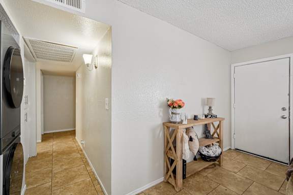 A hallway with a table and a vase of flowers.
