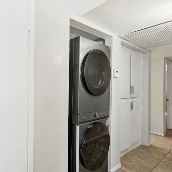 A modern black washing machine in a white laundry room.