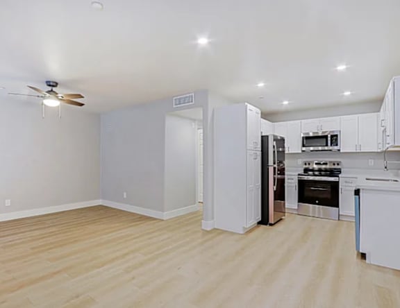 A kitchen with a refrigerator, oven, and microwave.