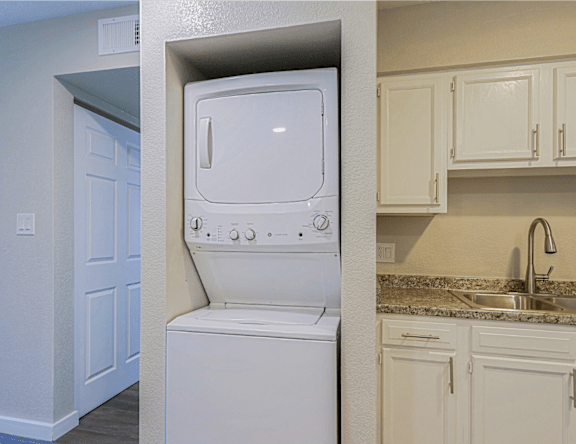 A white washing machine is built into a wall in a kitchen.