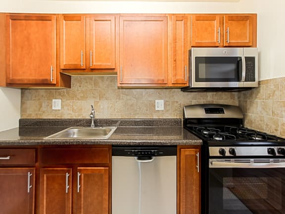 kitchen with stainless steel appliances and tile backsplash at penn view apartments in washington dc