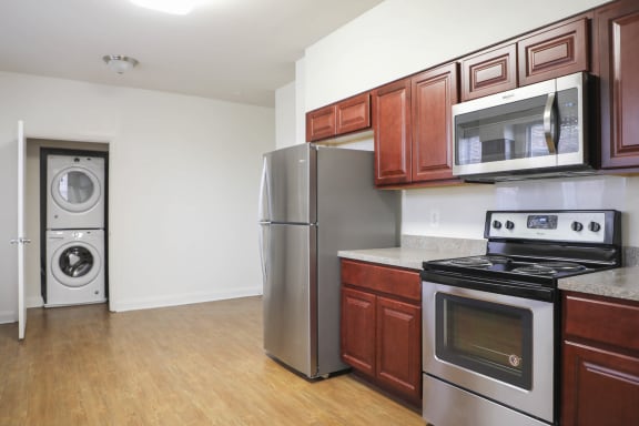 a kitchen with wood cabinets and stainless steel appliances  at Ingram Manor Apartments, Pikesville, MD, 21208