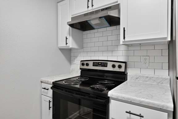 A black and white kitchen with a stove and oven.