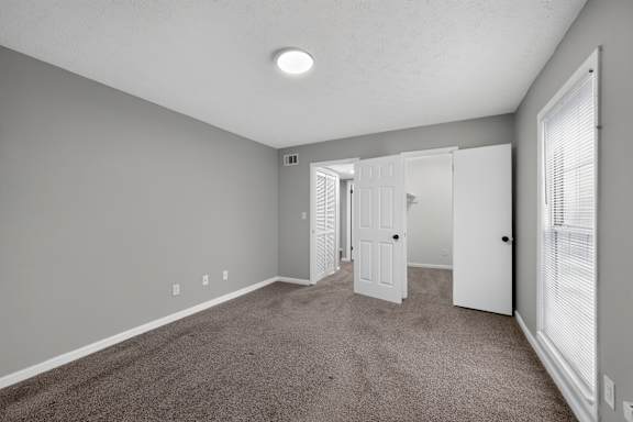 A room with a carpeted floor and white walls.