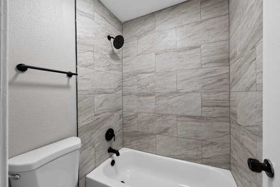 A white toilet is next to a white bathtub in a bathroom.