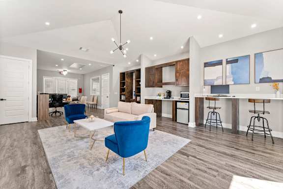 A modern living room with a blue chair and a white couch.