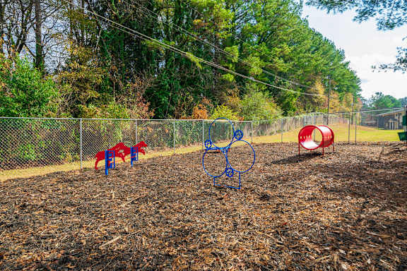 A playground with a slide, swings, and a seesaw.