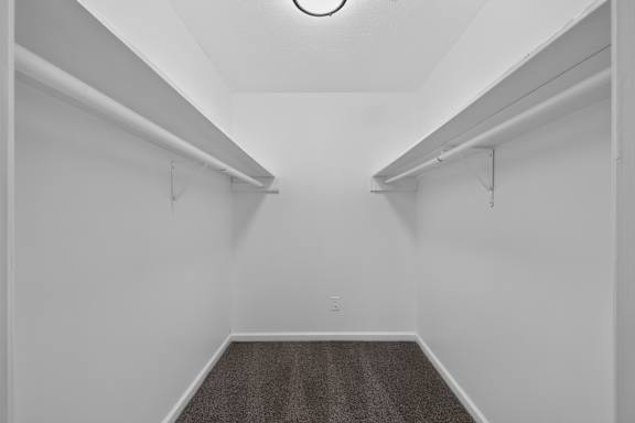 A long hallway with a carpeted floor and white walls.