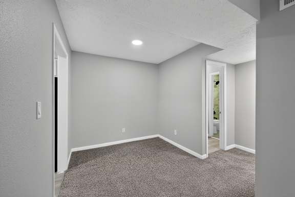 A room with a carpeted floor and white walls.