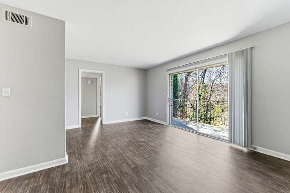 A room with a sliding glass door leading to a balcony.