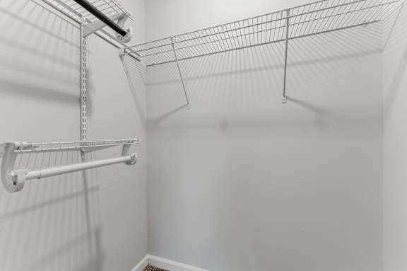 A wire shelving unit is mounted on a white wall.
