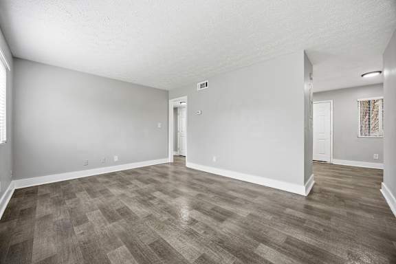 A room with wooden flooring and white walls.